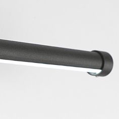 a close up view of a black handle on a light fixture with a white wall in the background