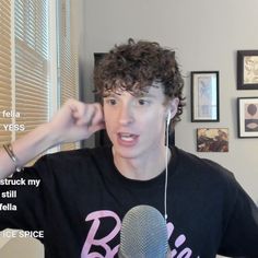 a young man is listening to music while holding a microphone in his right hand and wearing headphones