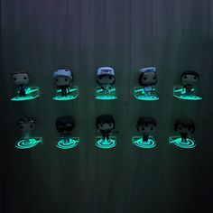 many pop vinyls are glowing in the dark with green light around them and on top of each other