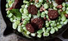 a skillet filled with vegetables and meatballs