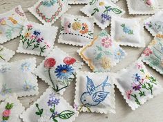 many embroidered flowers and birds are on the table