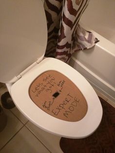 a toilet seat with writing on the lid