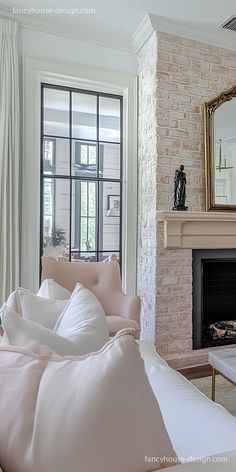 a living room filled with furniture and a fire place in front of a brick wall