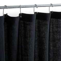 black curtains hanging on a metal rod