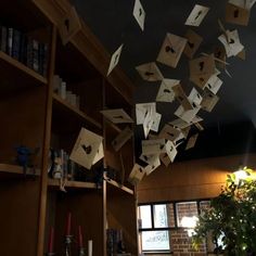 many papers are flying in the air above a bookshelf