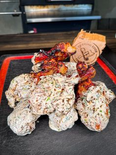 some kind of food sitting on top of a black tray in front of a pizza oven