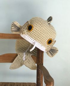 a crocheted stuffed fish sitting on top of a wooden chair