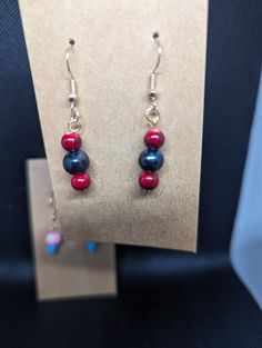 Dangle earrings made with red stone beads and black pearls. A classic combination that pairs well with many types of outfits! Red And Black Beaded Drop Earrings, Red Earrings With Black Beads For Gift, Red Earrings With Black Beads As Gift, Elegant Red Earrings With Black Beads, Red Dangle Pearl Earrings For Jewelry Making, Red Drop Earrings With Black Beads, Black Pearls, Pearl Dangle Earrings, Of Outfits