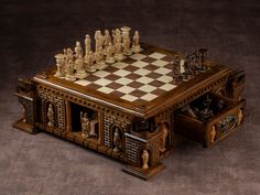 a wooden chess set sitting on top of a table next to a chest of drawers