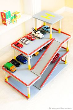 three children's toy cars are stacked on top of each other in a playroom