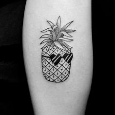 a black and white photo of a pineapple tattoo on the left calf's leg