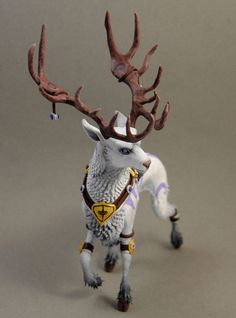 a white and brown animal with antlers on it's head