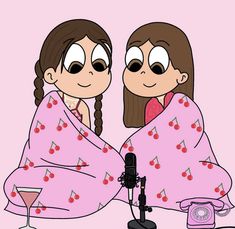 two women wrapped in pink are sitting next to each other and one is holding a microphone