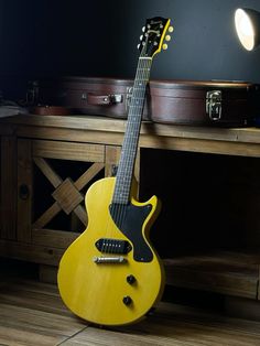 a yellow guitar sitting on top of a wooden floor