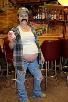 a man with fake moustache holding a drink in front of his belly and mustache