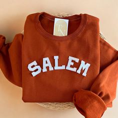 Cozy up with our Salem Crewneck Sweatshirt this halloween season! Perfect for all halloween season lovers!  - Sweatshirt is super soft and comfy! ♡ - Sweatshirt composition: 50% cotton, 50% polyester - All our sweatshirts run a unisex fit. They are naturally oversized, so we normally recommend your true size. But if you like a more baggy look, we recommend sizing up. - These letters are iron-on patched and is heat pressed, not embroidered. But rest assured they've been tested and won't fall off! Vintage Halloween Sweatshirt, Crew Neck T-shirt For Game Day In Fall, Fall Fan Apparel Cotton Sweatshirt, Customizable Fall Sweatshirt With School Spirit, Fall School Spirit Relaxed Fit Sweatshirt, Fall School Spirit Sweatshirt With Relaxed Fit, School Spirit Sweatshirt With Relaxed Fit For Fall, Customizable Fall Sweatshirt For College, School Spirit Long Sleeve T-shirt For Fall