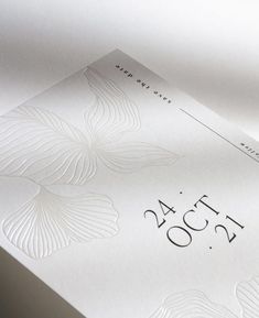 a close up view of the numbers and date on a white card with silver foil