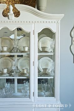 a white china cabinet with glass doors and dishes on it, in front of the words tips for making money painting furniture