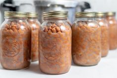 four jars filled with food sitting on top of a counter