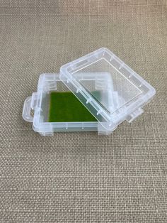 two plastic containers filled with green liquid on top of a carpeted floor next to each other