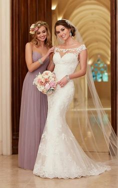 two bridesmaids pose for the camera in their wedding gowns and veils