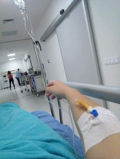 a person in a hospital bed with an iv tube attached to the end of it