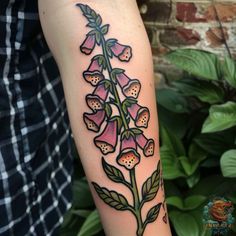 a woman's arm with tattoos on it and flowers in the middle of her arm