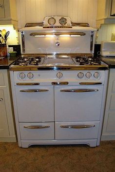 a white stove top oven sitting inside of a kitchen