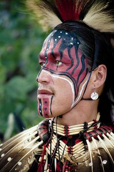 a native american man with his face painted red and black