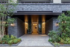 the entrance to an apartment building with plants and trees