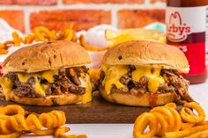 two pulled pork sandwiches with cheese and onion rings