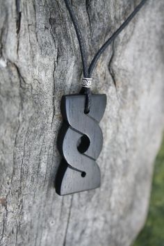 "This beautiful and unique hand-carved Celtic Knot Pendant will be made for you, or a loved one, in my studio on the West of Ireland. Adorned with a dainty Celtic silver bead, this stunning eternity knot necklace features a piece of ebony wood, recycled from musical instruments constructed by a local luthier. As a musician myself, I take enormous satisfaction in creating a necklace whose inherent wood has previously featured in a beautiful hand-made guitar. Also, part of ebony's attractiveness i Artisan Carved Black Necklace, Artisan Black Engraved Necklace, Artisan Black Carved Necklace, Artisan Black Carved Jewelry, Handmade Ebony Necklaces For Gifts, Handmade Ebony Necklace For Gift, Wood Anniversary Gift For Him, Celtic Eternity Knot, Eternity Knot