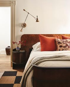 a bedroom with a bed, nightstand and two lamps on the side tables in front of it