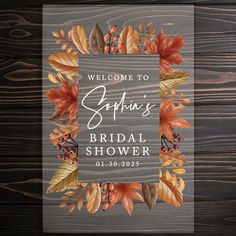 an autumn bridal shower sign on a wooden background with leaves and acorns