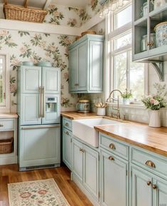 a kitchen with blue cabinets and floral wallpaper on the walls, along with wooden floors