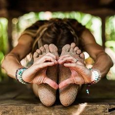 a woman with her hands in the air while laying on top of a wooden table