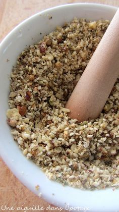 a white bowl filled with granola and a wooden spoon