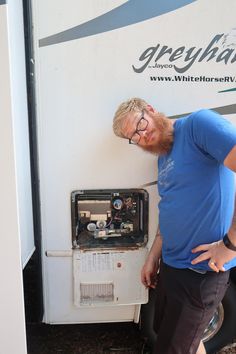 a man leaning against the side of a white rv