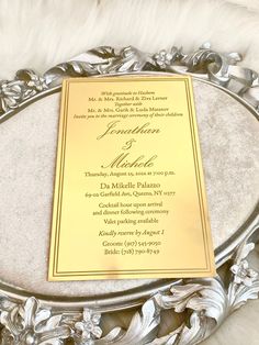 a gold and silver wedding menu on a white furnishing