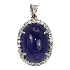 This is part of Chairish’s Fine Jewelry assortment.  WEIGHT: 7.8 grams MAIN STONE: Tanzanite, 20 cts OTHER STONES: Diamonds, .50 ct, VVS-VSI clarity, G-H color METAL: 18k white gold  This Tanzanite Cabochon Pendant with a Diamond surround is done in 18K White Gold and is brand new and never been worn. This tanzanite is a gorgeous shade of blue with nice metrics and it is large 21 Carats with a Diamond Border of .50 Carats of Diamonds. This pendant is high domed just like the matching ring and as Luxury Diamond Gemstones With Cabochon Cut, Luxury Diamond Cabochon Gemstones, Luxury Oval Cabochon Gemstones, Oval Diamond Gemstones For Formal Occasions, Formal Oval Diamond Gemstones, Classic Sapphire Gemstones For Formal Occasion, Oval Diamond Cabochons With Polished Finish, Luxury Formal Hallmarked Gemstones, Luxury Oval Cabochon Diamond Gemstones