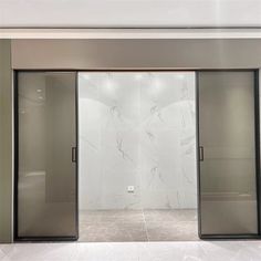 an empty room with glass doors and marble walls