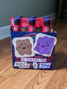 four bottles of soda sitting on top of a wooden floor next to each other in a holder