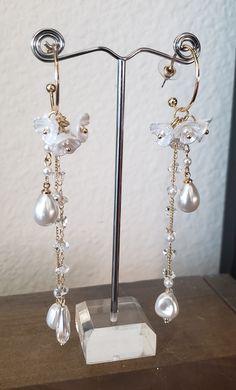 White Flower Dangle Drop Earrings Measuring a little over 4 inches long, these beautiful earrings feature lustrous high-quality acrylic flowers accented with beautiful faux pearl and crystal. Perfect for Bridal and Wedding wear, Anniversary, Easter, high tea, and Brunch! Details: High-Grade Acrylic Floral Motifs Crystal Faux Pearl 4 inches in Length Selectively Procured Stock item Ships in 1-3 days White Crystal Clip-on Earrings For Party, Elegant Dangle Clip-on Flower Earrings, Elegant White Flower Earrings With Pearl Charm, Elegant Clip-on Dangle Flower Earrings, White Pearl Clip-on Earrings With Pearl Charm, Feminine Flower Dangle Earrings With Pearl Drop, Gift White Pearl Chandelier Earrings, White Clip-on Bridal Earrings For Party, Formal Dangle Flower Earrings With Pearl Drop