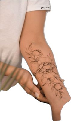 a woman's arm with flowers on it and her hand holding the wrist tattoo