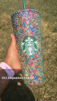 a hand holding a starbucks cup with sprinkles on it and a green straw