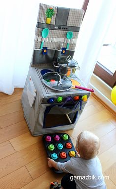 a toddler playing with a toy kitchen set