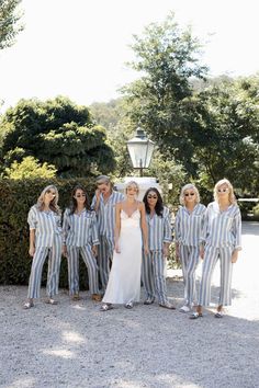 a group of people that are standing in front of some bushes with sunglasses on their heads