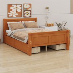 a bed sitting on top of a hard wood floor next to a white vase with flowers