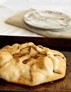 an apple pie sitting on top of a wooden cutting board