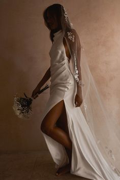 a woman in a white wedding dress and veil